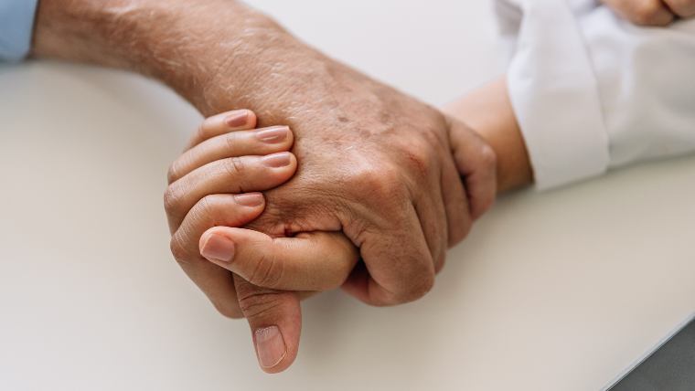 Hand holding another hand.