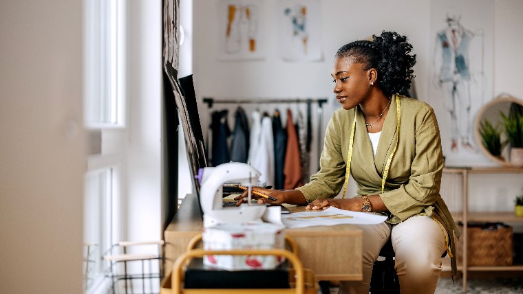 Fashion designer using sewing machine.