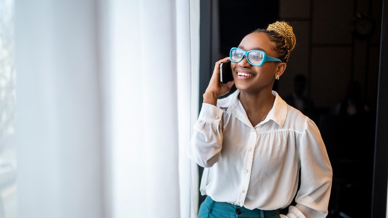 Young woman smiling and talking on phone.