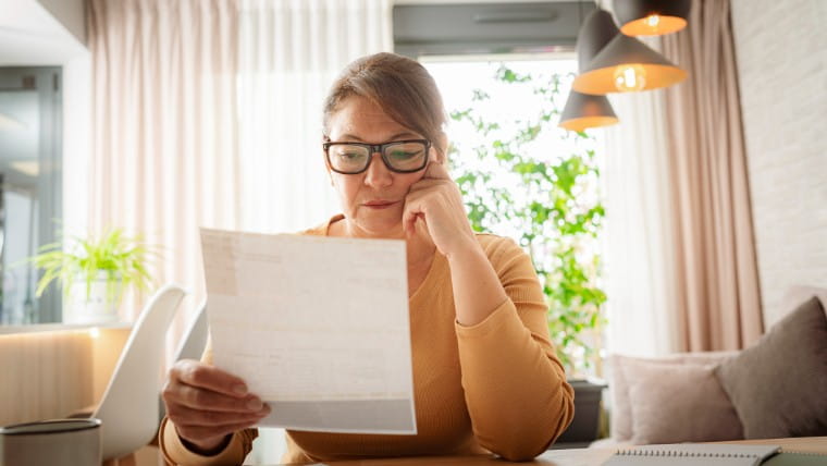 Concerned woman reviewing paperwork.