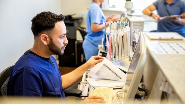 Nurse working at check out desk.