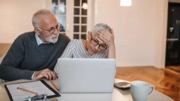 concerned senior couple reviewing information on their laptop