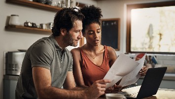 Young couple reviewing financial documents together.