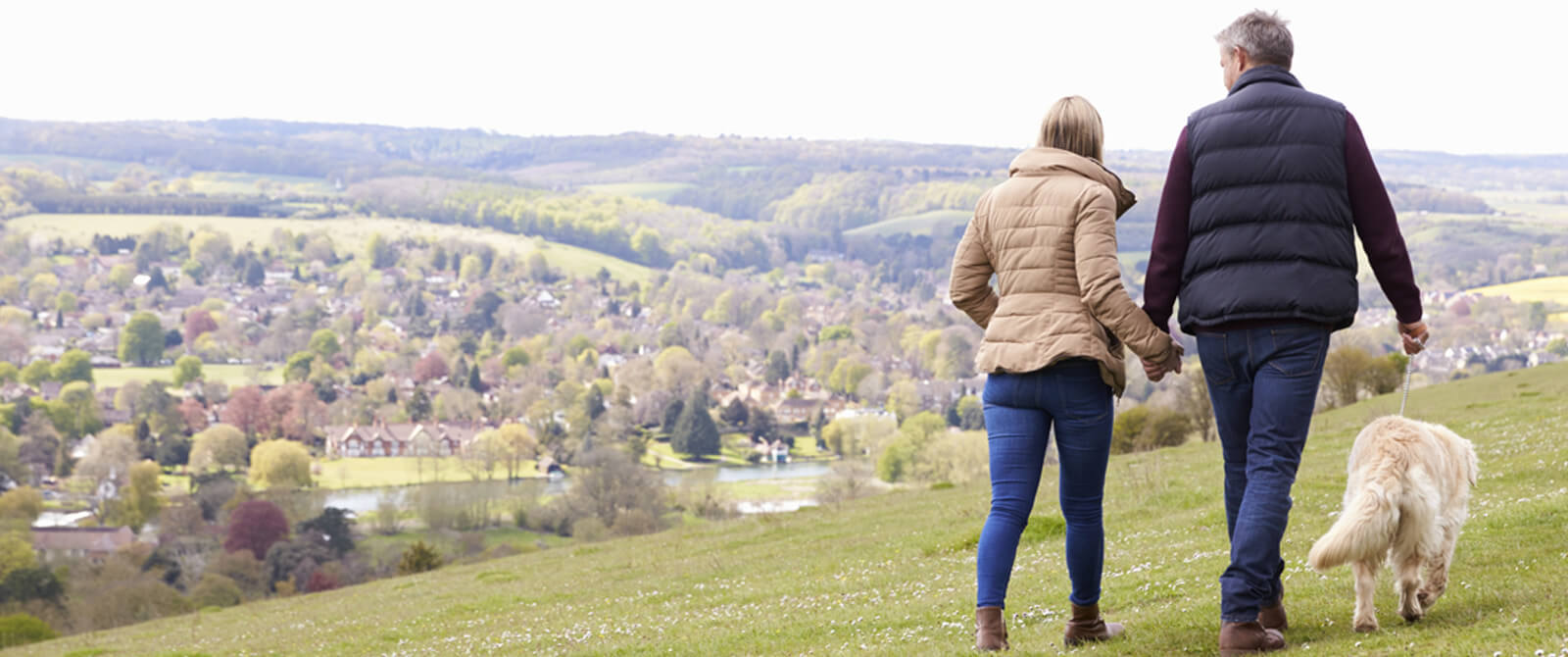 A couple enjoying a countryside walk with their dog
