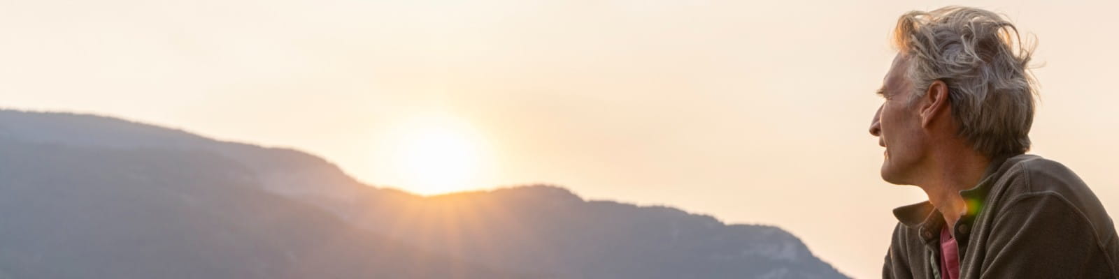 Man looking at rising sun.
