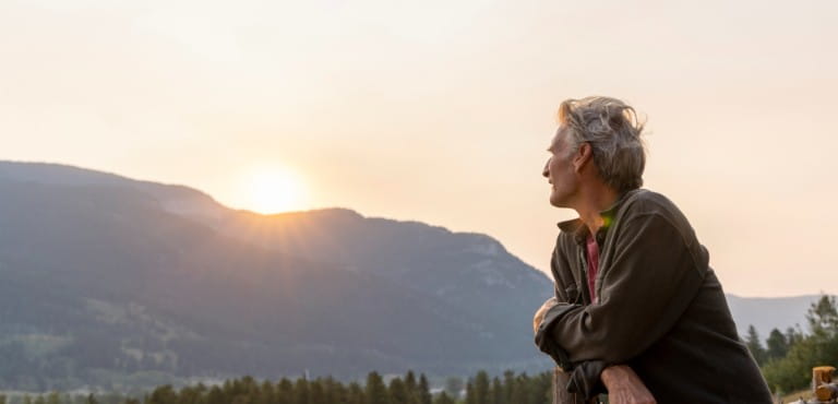 Man looking at rising sun.