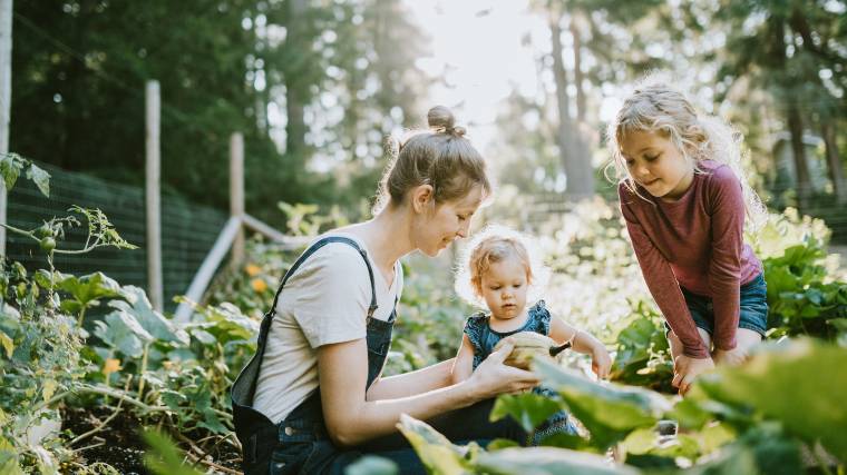 Mother working in a garden with two small children