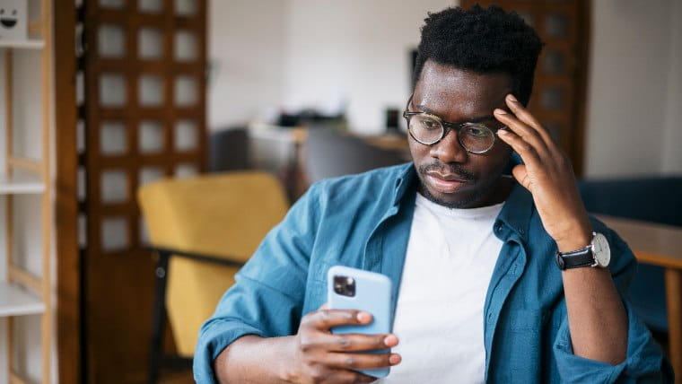 Disappointed man looking at his smartphone.