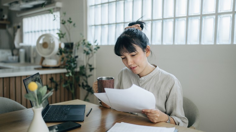 Young woman reading financial documents.