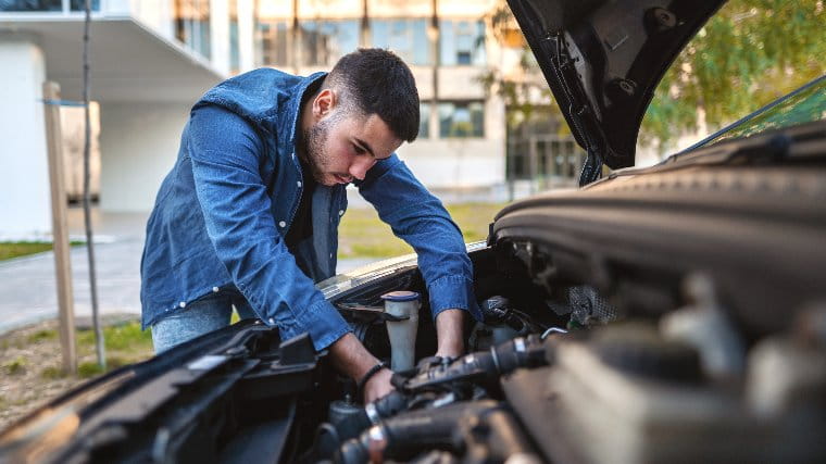 Young man working on his car.