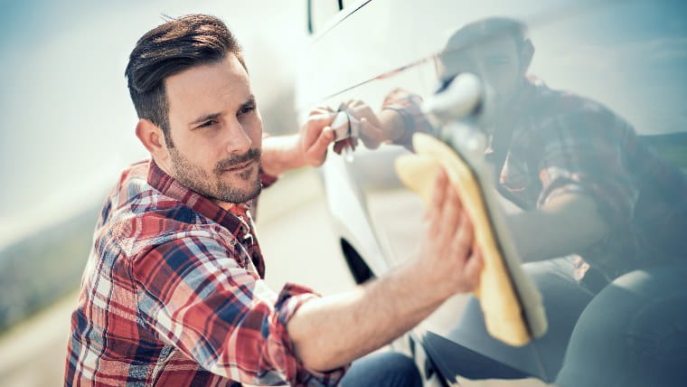 Man handwashes his car.