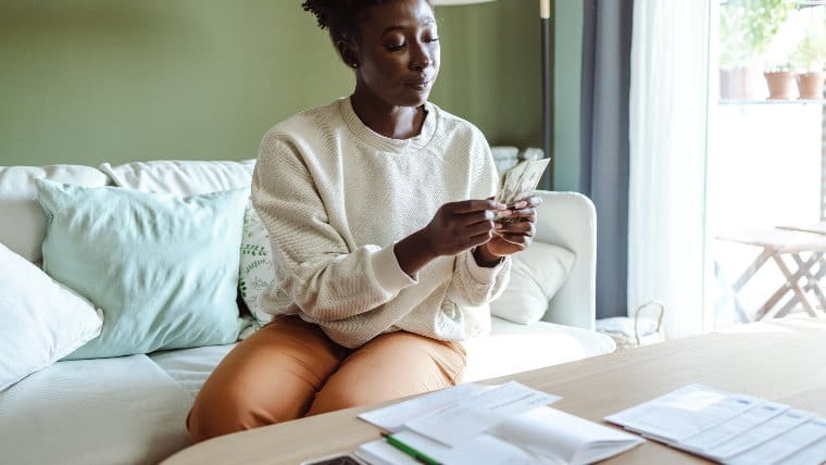 Woman sorting cash into envelopes.