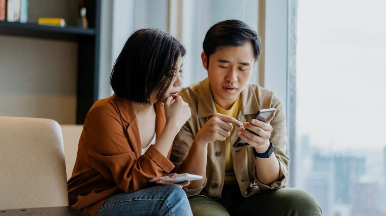 Couple looking at phone and having conversation.