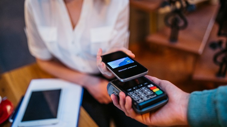 Woman using smartphone to make payment.