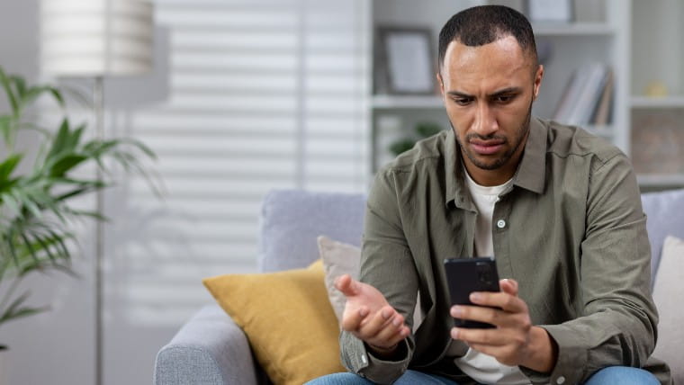 Worried young man checking phone.