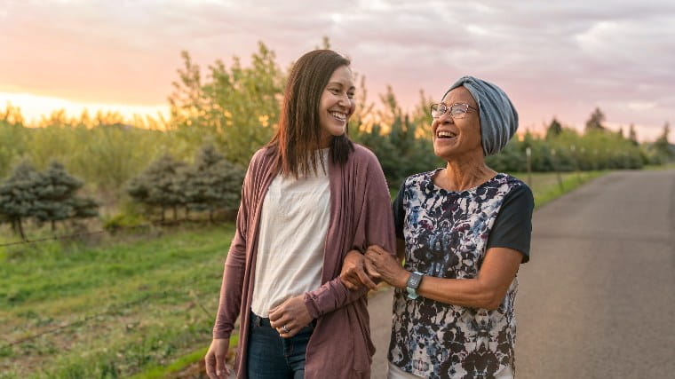 Two women walking and talking outside.