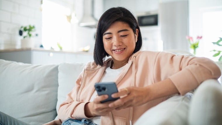 Young woman reading good news on her cellphone.