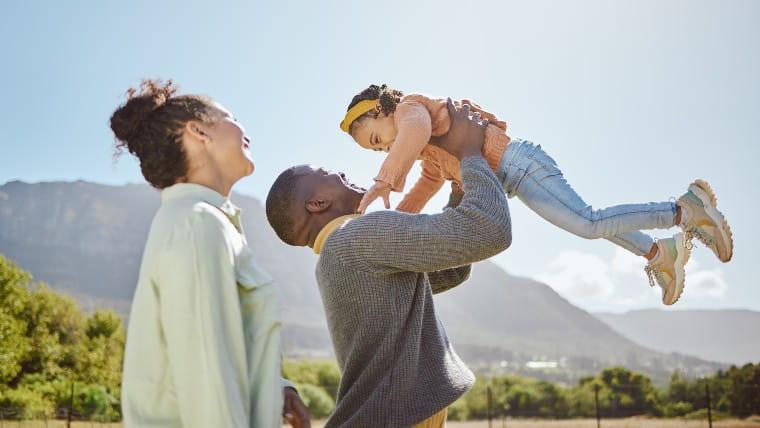 Family of three walking outdoors.