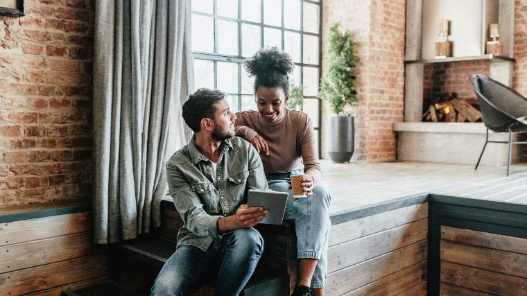 Young couple reviewing offer on tablet.