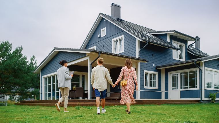 Couple walking around house with real estate agent.