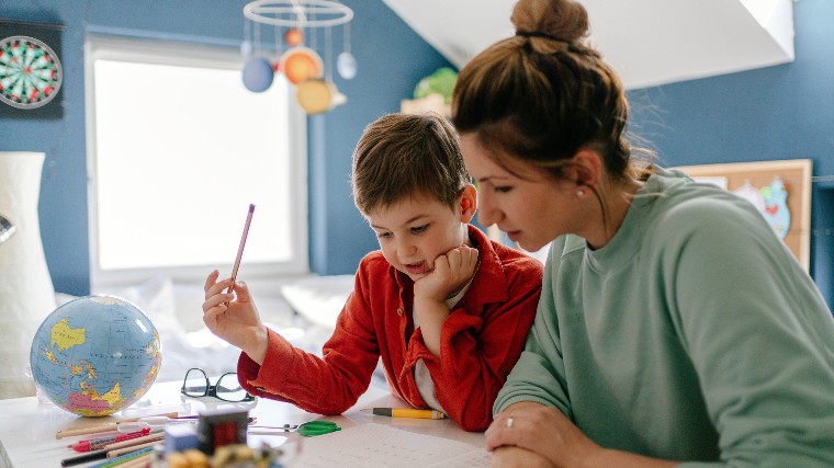Mother homeschooling small child.