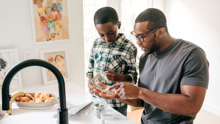 Father teaches young son about money.