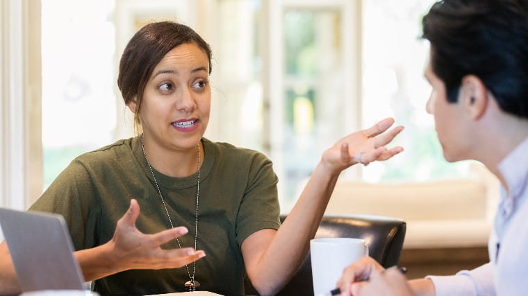 Woman in military fatigues speaking with financial advisor.