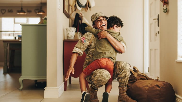 Military mother hugging young son.