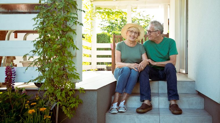 Senior couple sitting together on the porch.