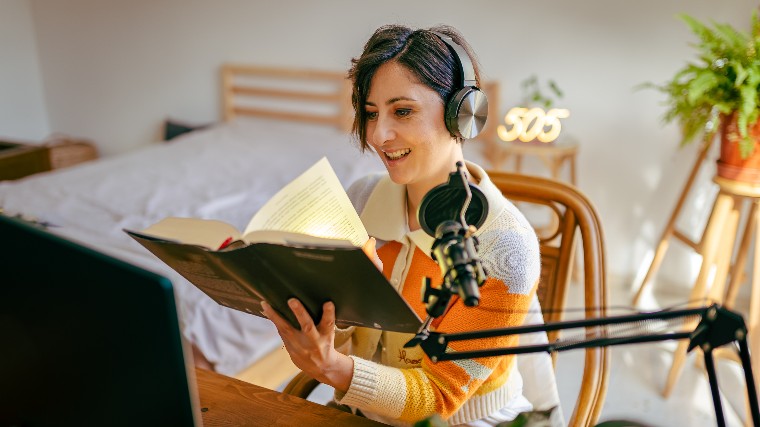Woman recording herself narrating a audiobook.