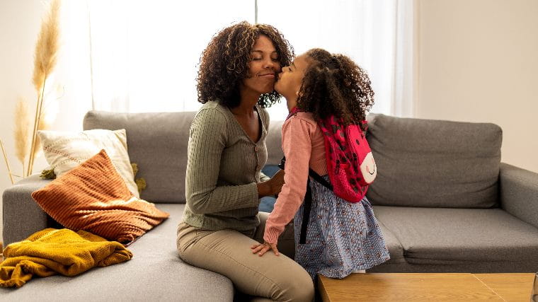 Mother helping young daughter get ready for school.