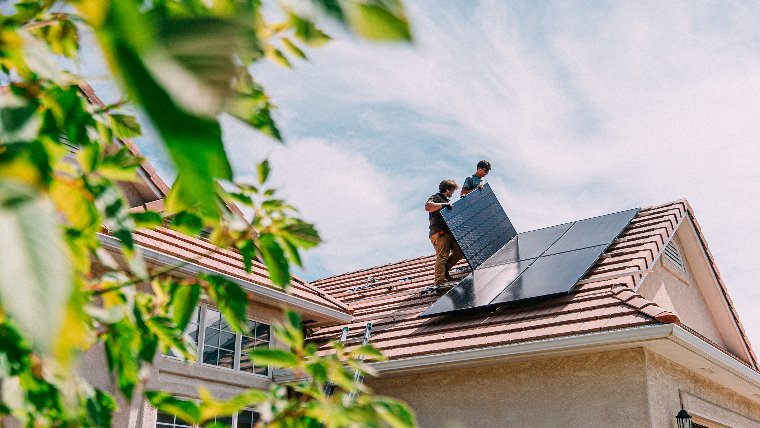 Solar panels being installed on roof of house.