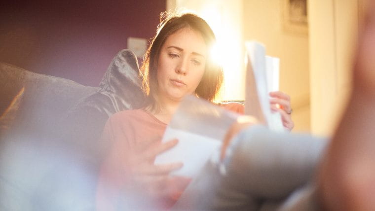 Concerned woman reading her bills.