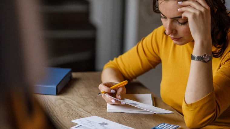 Stressed out woman looking at her bills.