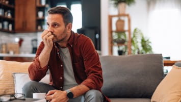 Stressed out man sitting on couch.