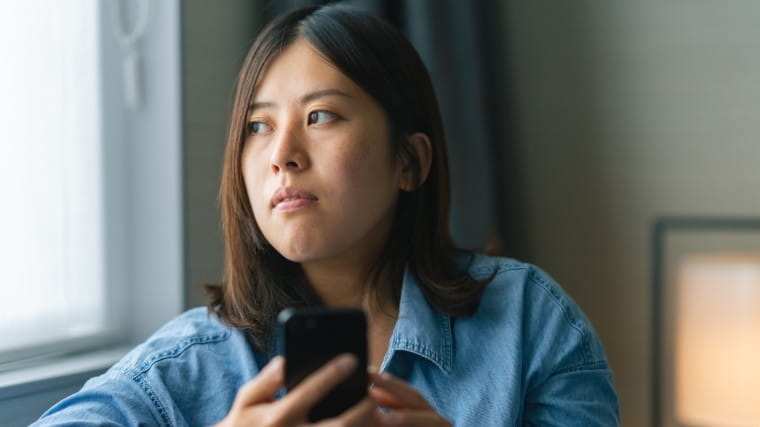 Distressed woman holding phone.