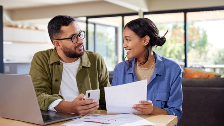 Young couple reviewing financial paperwork together.
