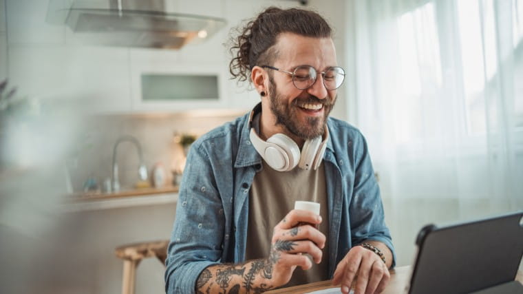 Young man smiling using the computer.