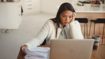 Stressed young woman using laptop.