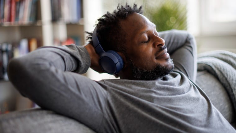 Relaxed man with eyes closed wearing headphones.