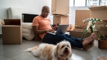 Man sitting on floor and using laptop.