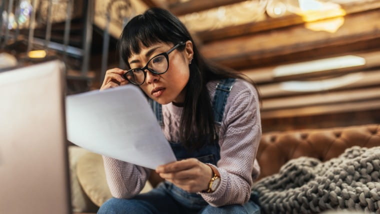 Woman reading paperwork closely.