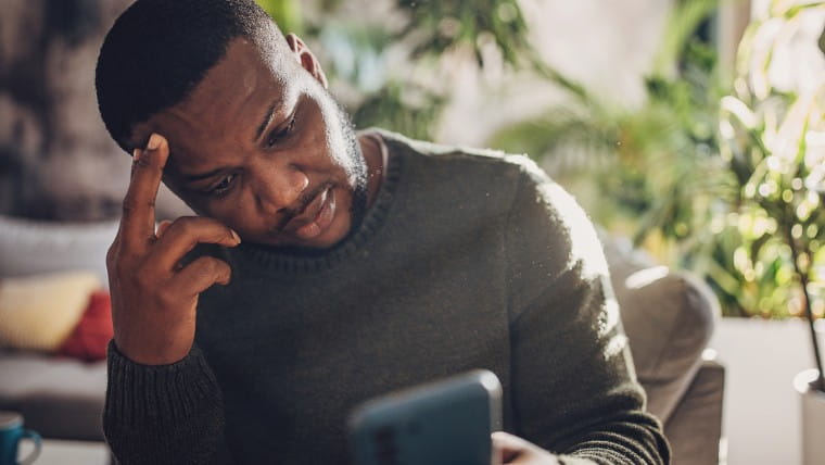 Worried man checking phone.