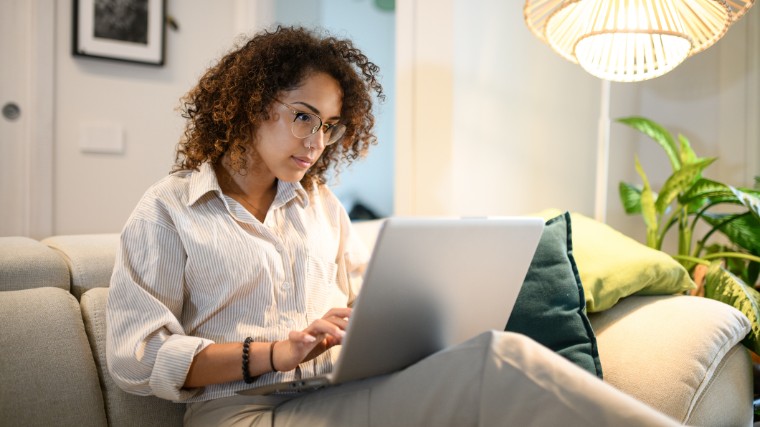 Young woman using laptop on the couch.