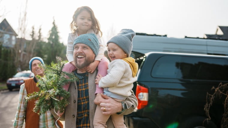 Father carrying young daughters during winter season.