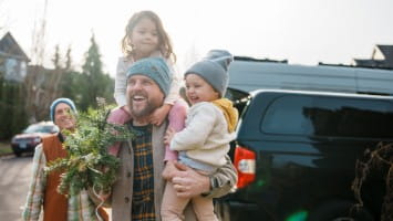 Father carrying young daughters during winter season.