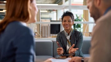 Couple speaking with loan officer.