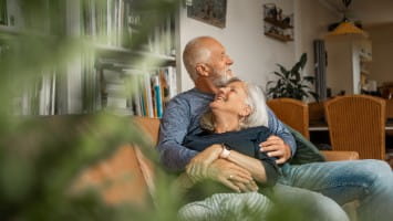 Senior couple sitting on couch together.
