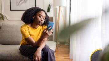 Stressed out young woman looking at phone.