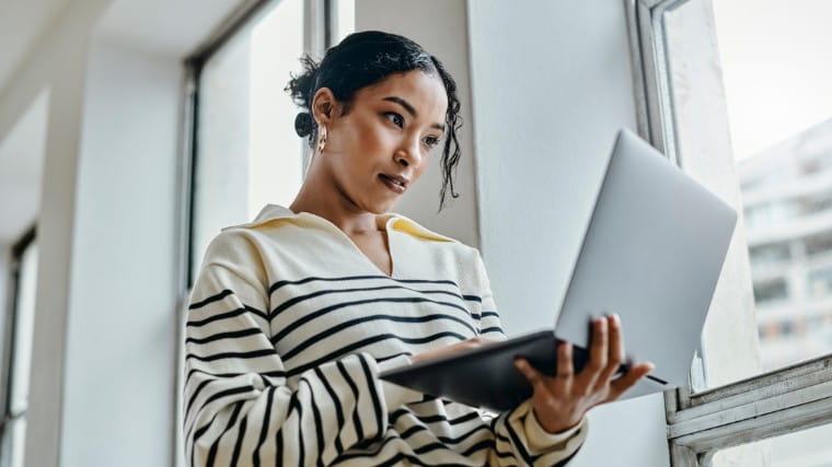 Young woman reading something on her laptop.